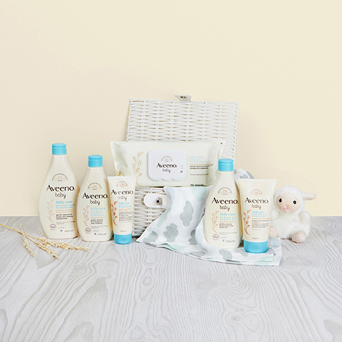 AVEENO® Baby Daily Care Range situated with blanket and cuddly toy